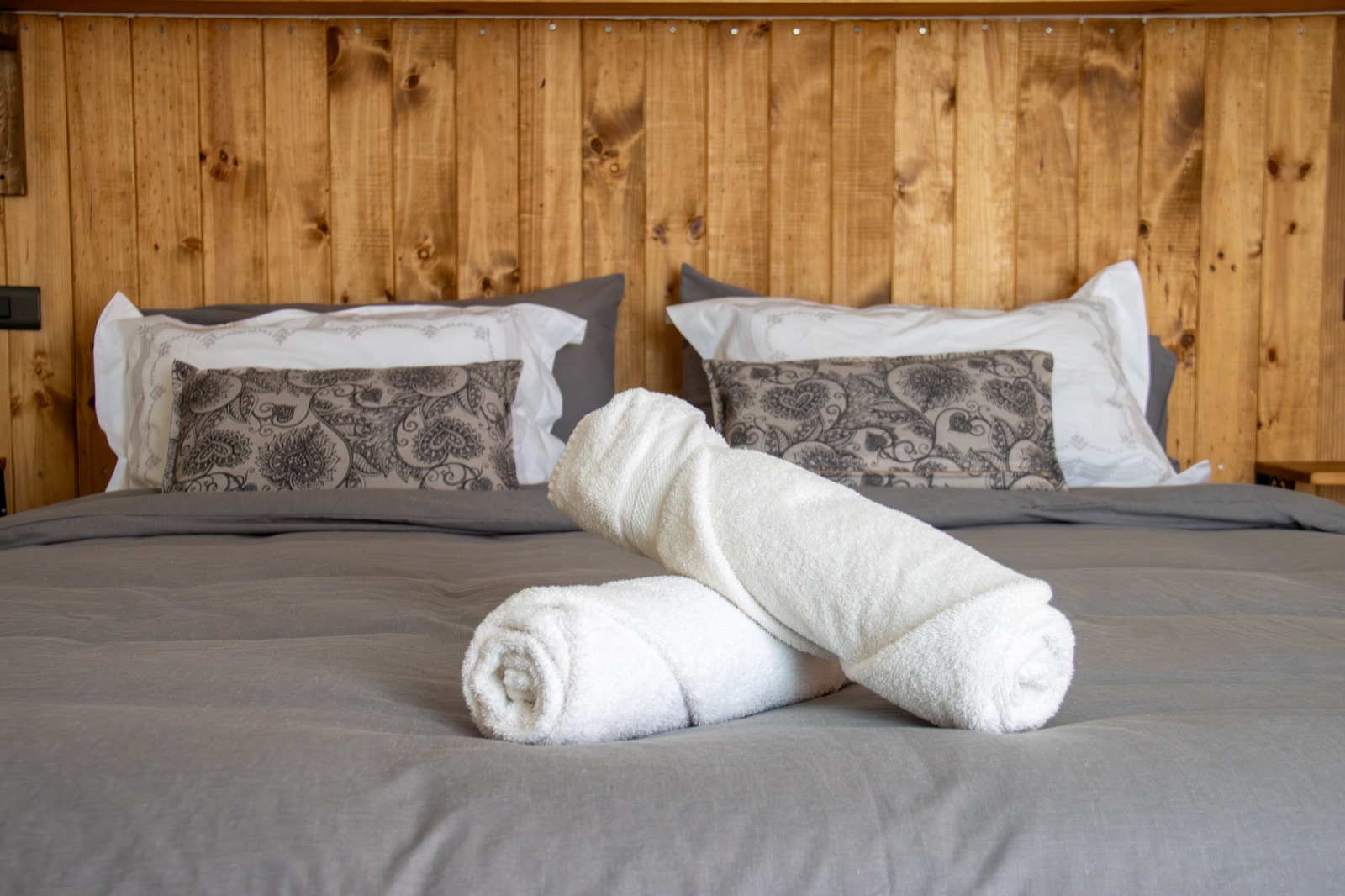 Cama de la suite con cojines y vista de madera